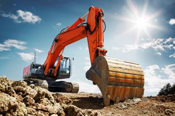 Pelleteuse rouge en action sur un chantier